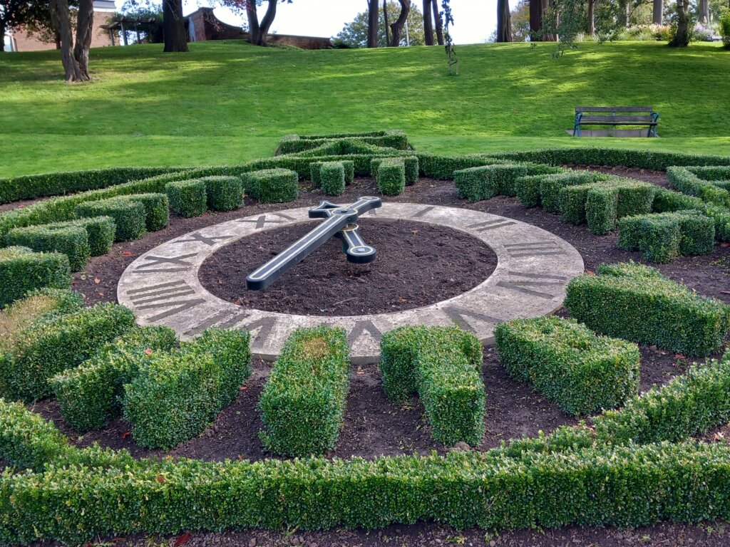 This photo shows the floral clock in winter. You can see privet hedge and clock face, but no flowers