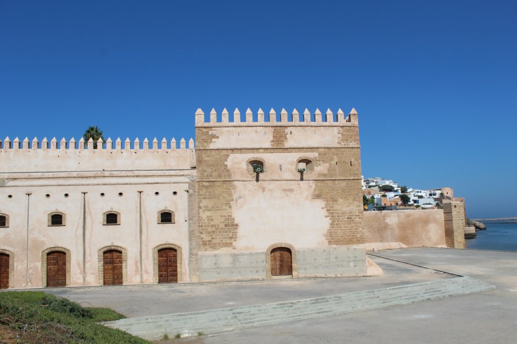 This photo shows the crenellated walls of the chellah set against a brilliant blue cloudless sky