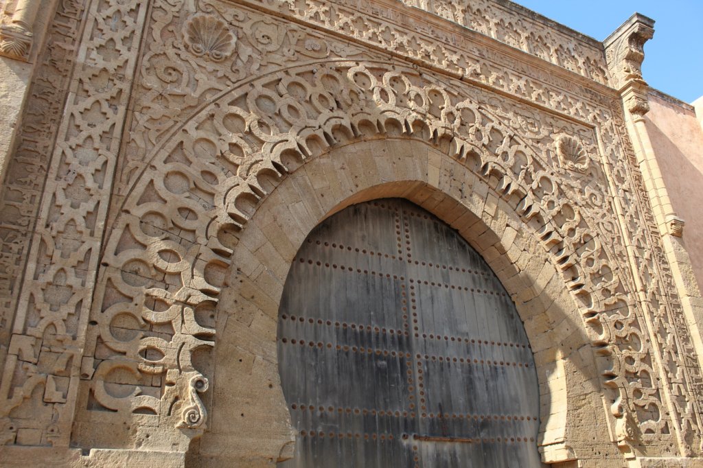 This photo shows a huge wooden gate with an elaborately decorated surround