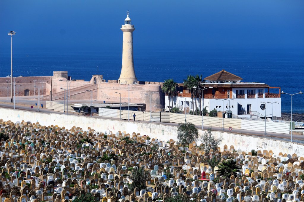 This photo shows hundreds of graves with a lighthouse in the background
