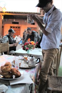 This photo shows our guide pouring mint tea from the pot into our glasses from a great height