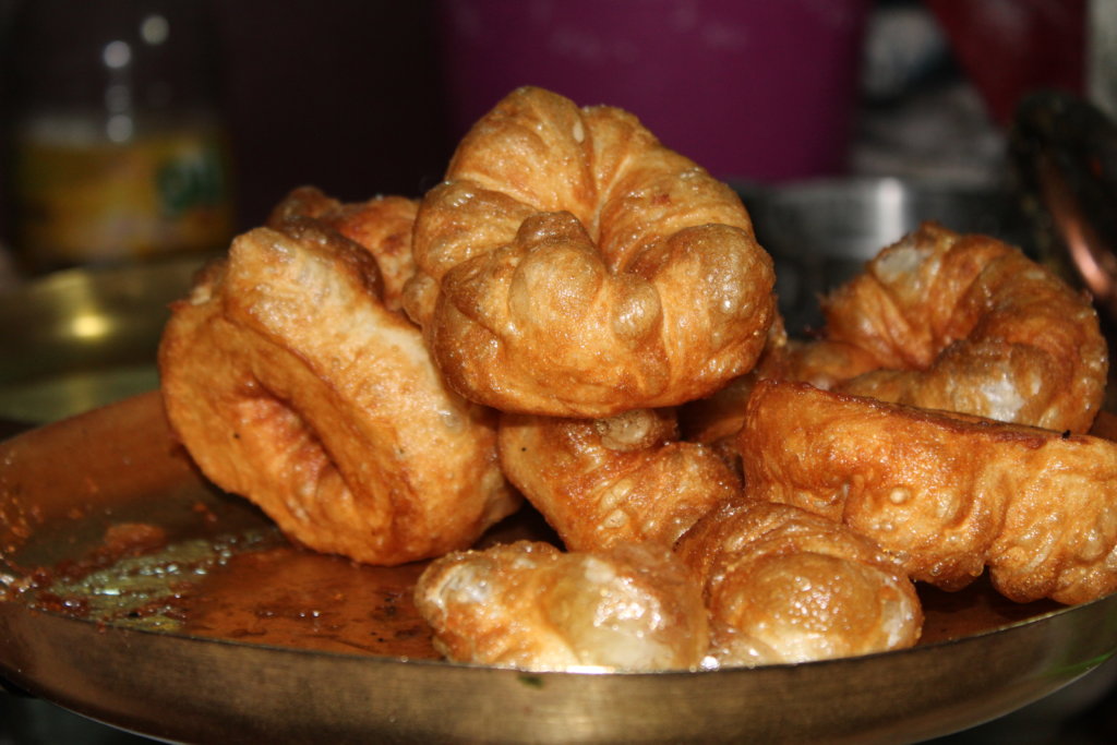 This photo shows a plate of freshly cooked doughnuts